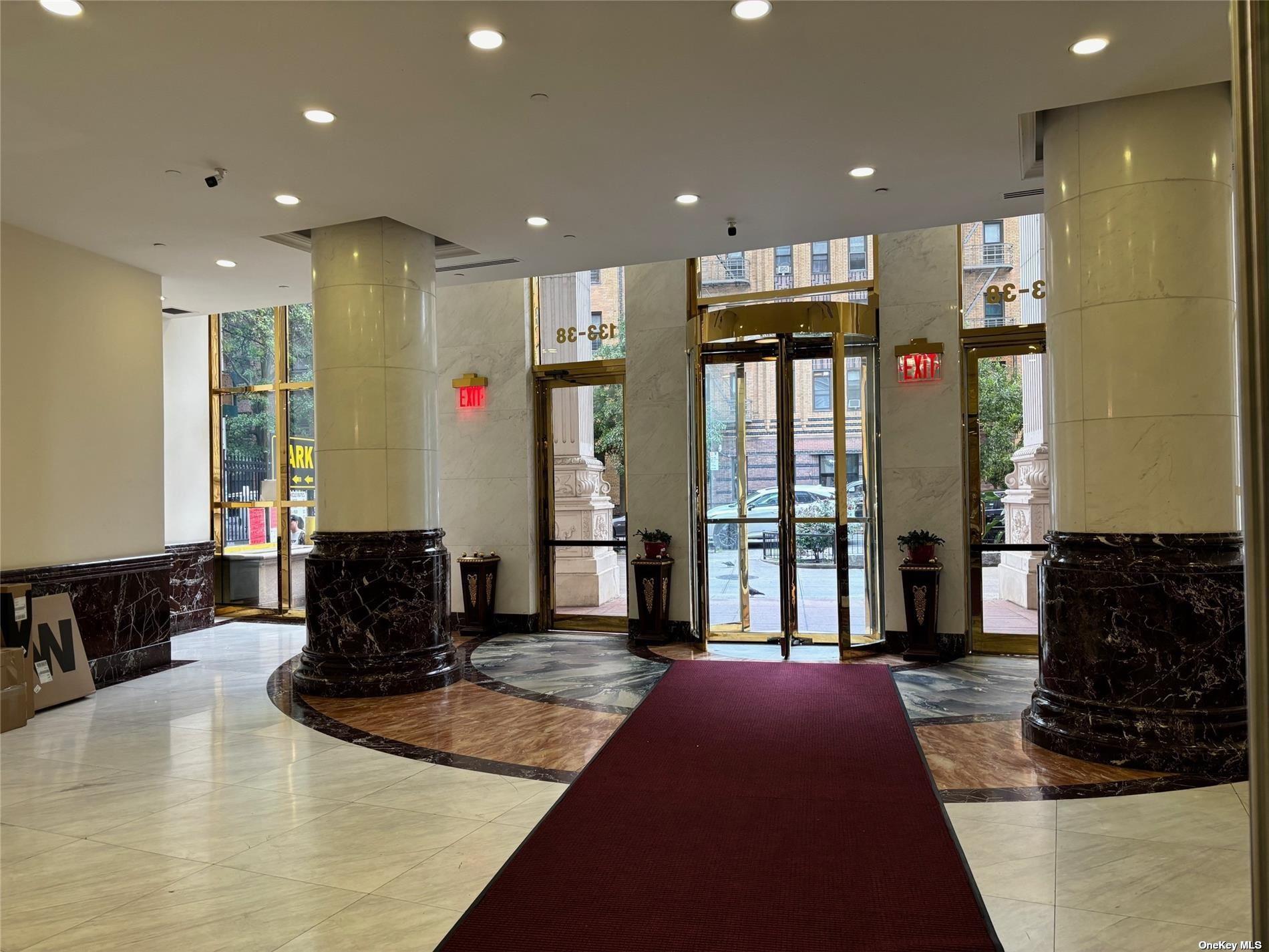 133-38 Sanford Avenue, Unit 9C Queens, NY 11355 - Photo 4 of 9 a living room with stainless steel appliances furniture a rug and a view