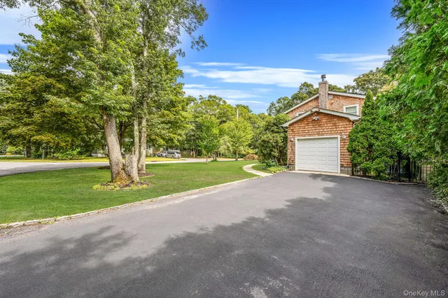 a view of a house with a big yard and large trees
