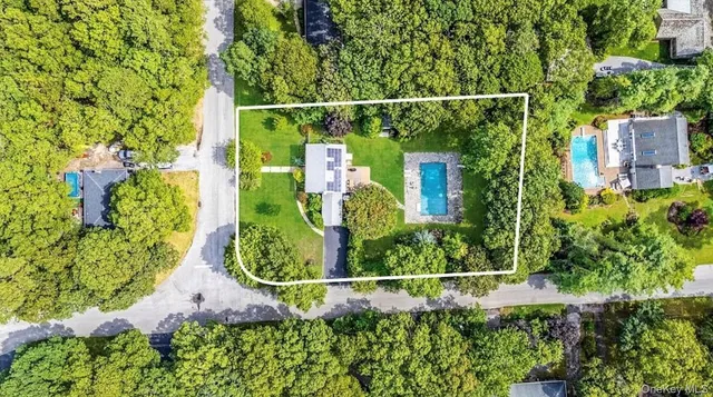 a view of a house with a tree and flower plants