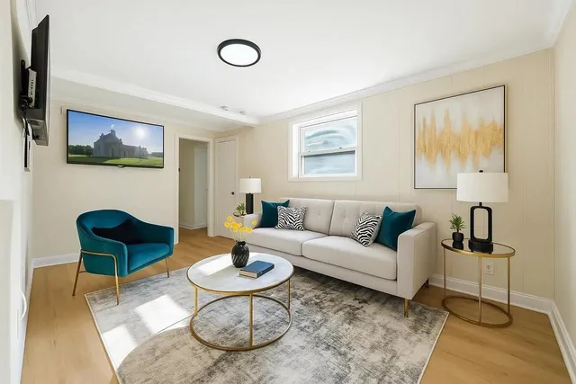 a living room with furniture and a wooden floor