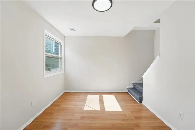 a view of a room with wooden floor and white walls