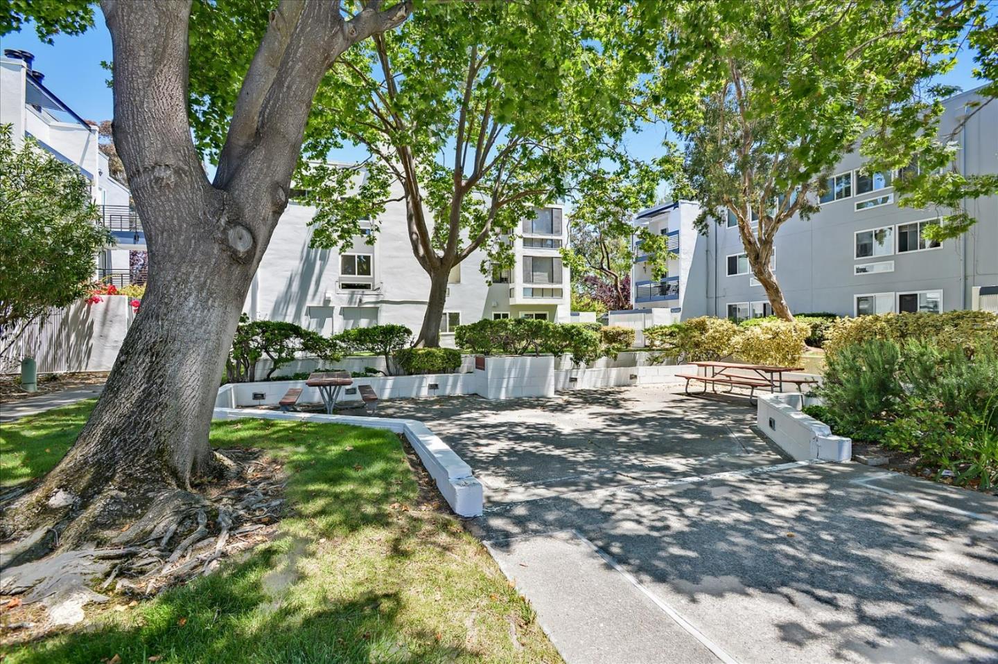 1033 Shell Boulevard, Unit 3 Foster City, CA 94404 - Photo 31 of 33 a view of a backyard with table and chairs and a large tree