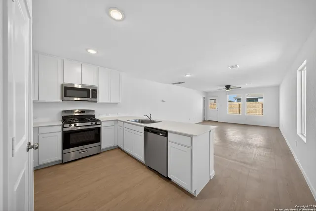 a kitchen with stainless steel appliances granite countertop a stove top oven a sink and a granite counter top