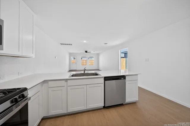 a kitchen with granite countertop a sink and cabinets