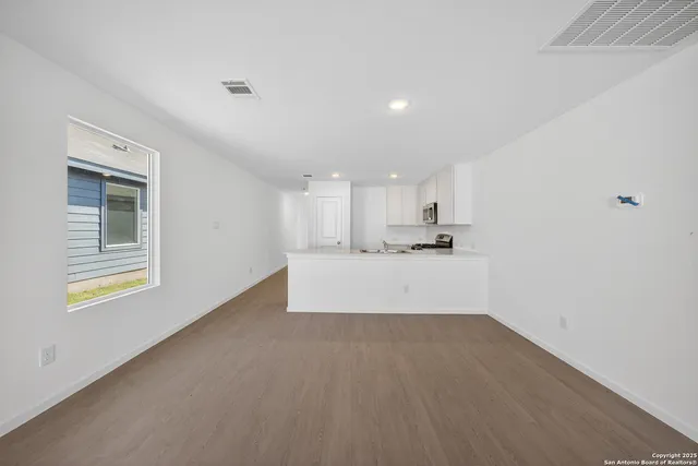 a view of a kitchen with wooden floor and windows