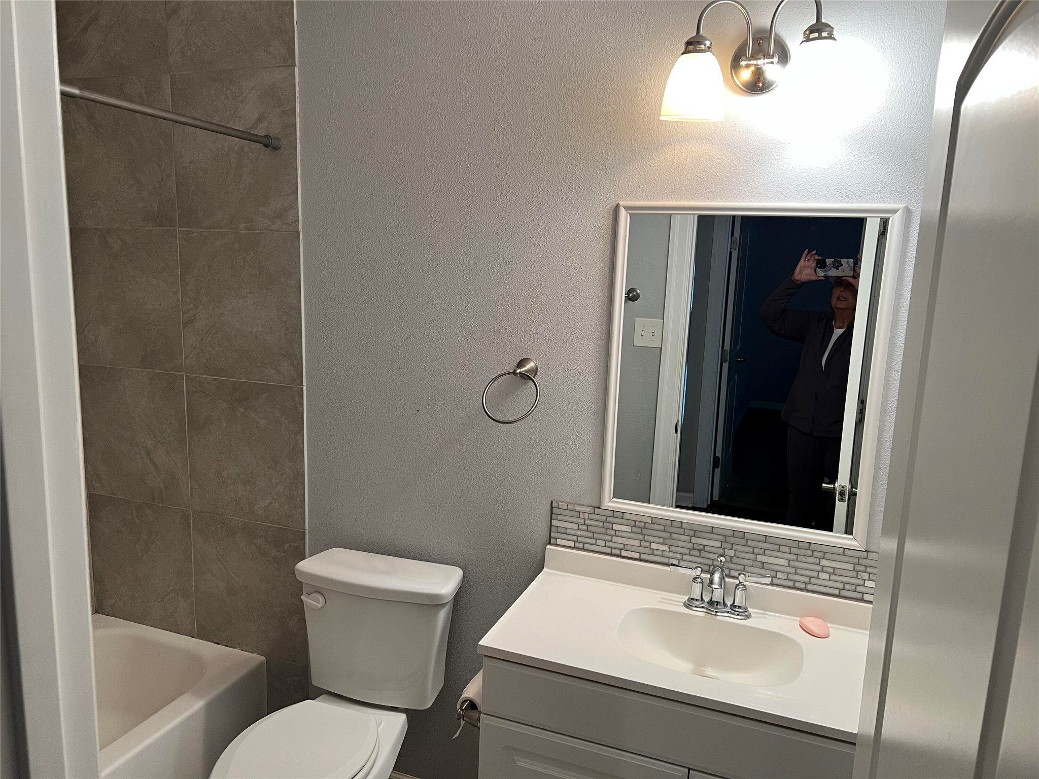 239 Old Firetower Road Bastrop, TX 78602 - Photo 7 of 39 Hall Bathroom with a textured wall, tasteful backsplash, vanity, and tub / shower combination