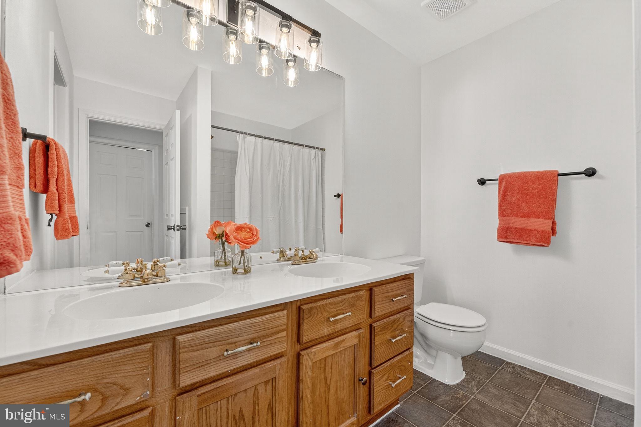 8210 Winstead Place Manassas, VA 20109 - Photo 15 of 27 a bathroom with a granite countertop toilet sink and mirror