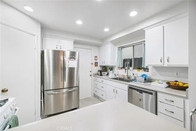 a open kitchen with a stove a refrigerator a dining table and chairs