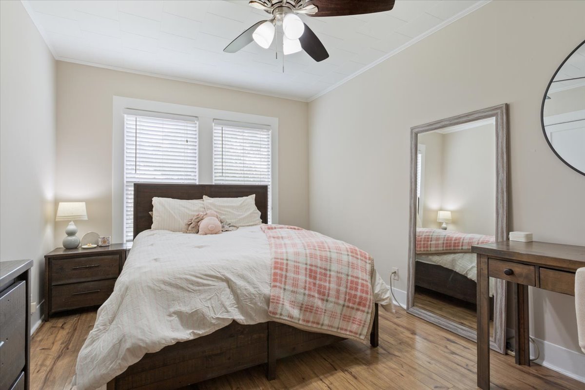 1607 North Harding Avenue Cameron, TX 76520 - Photo 22 of 37 Well-lit sleeping quarters with a ceiling fan for comfort and durable hardwood floors.