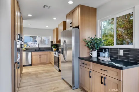 a kitchen with stainless steel appliances a refrigerator sink and cabinets