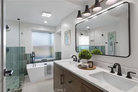 a bathroom with a sink a potted plant and a shower