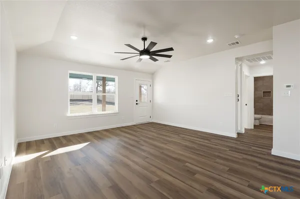 a kitchen with granite countertop a sink and a stove top oven with wooden floor