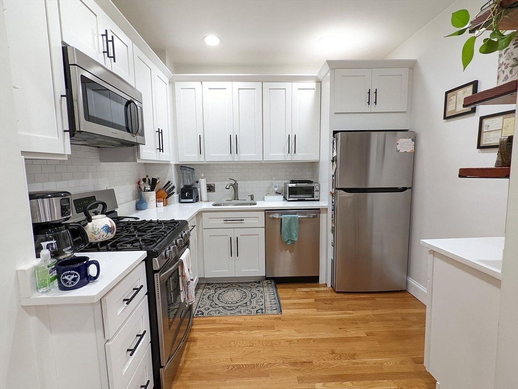 a kitchen with stainless steel appliances granite countertop a refrigerator sink stove microwave and cabinets