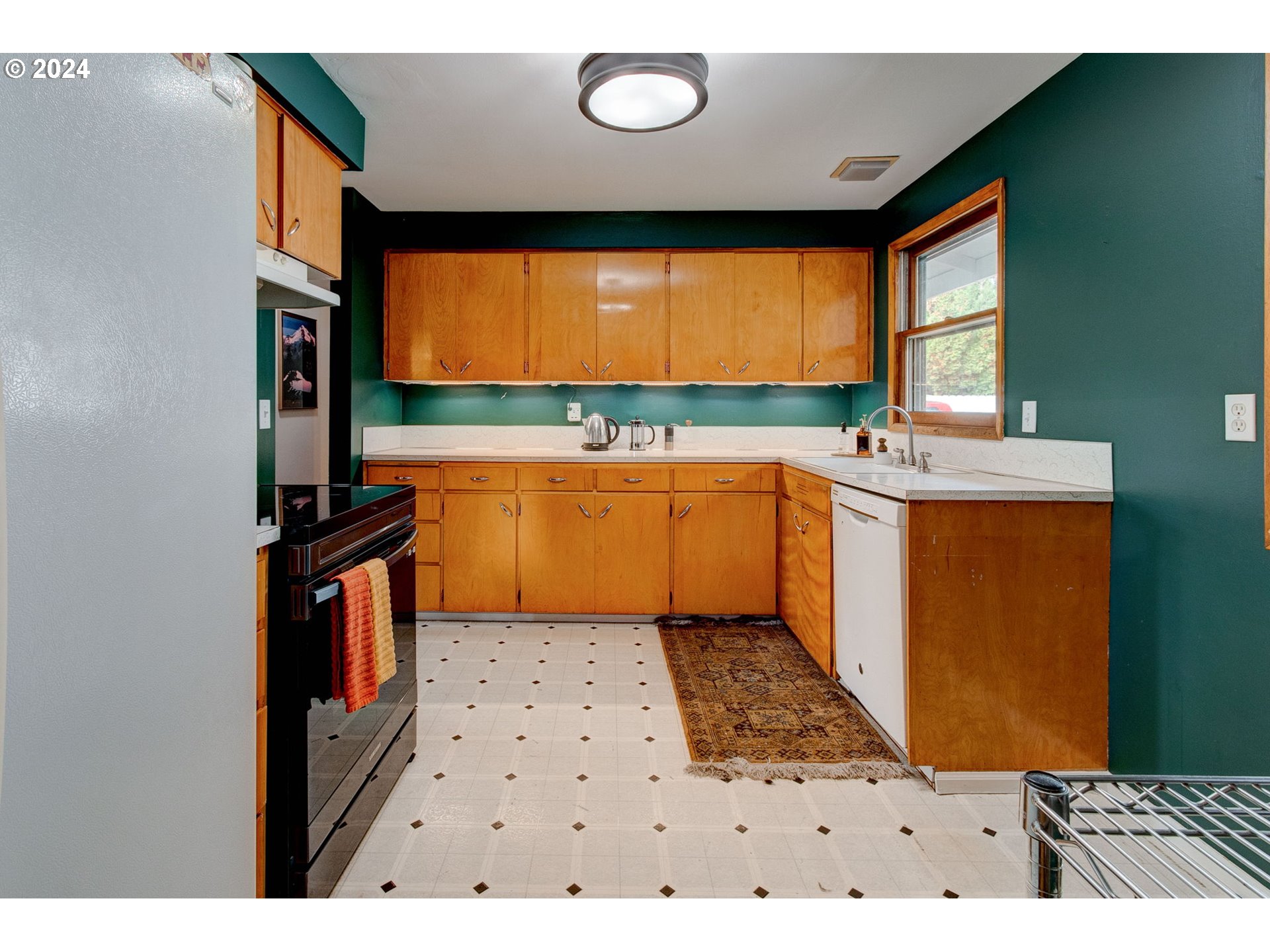 14205 Southeast Salmon Street Portland, OR 97233 - Photo 7 of 35 a kitchen with stainless steel appliances a sink a stove top oven a chimney and a window