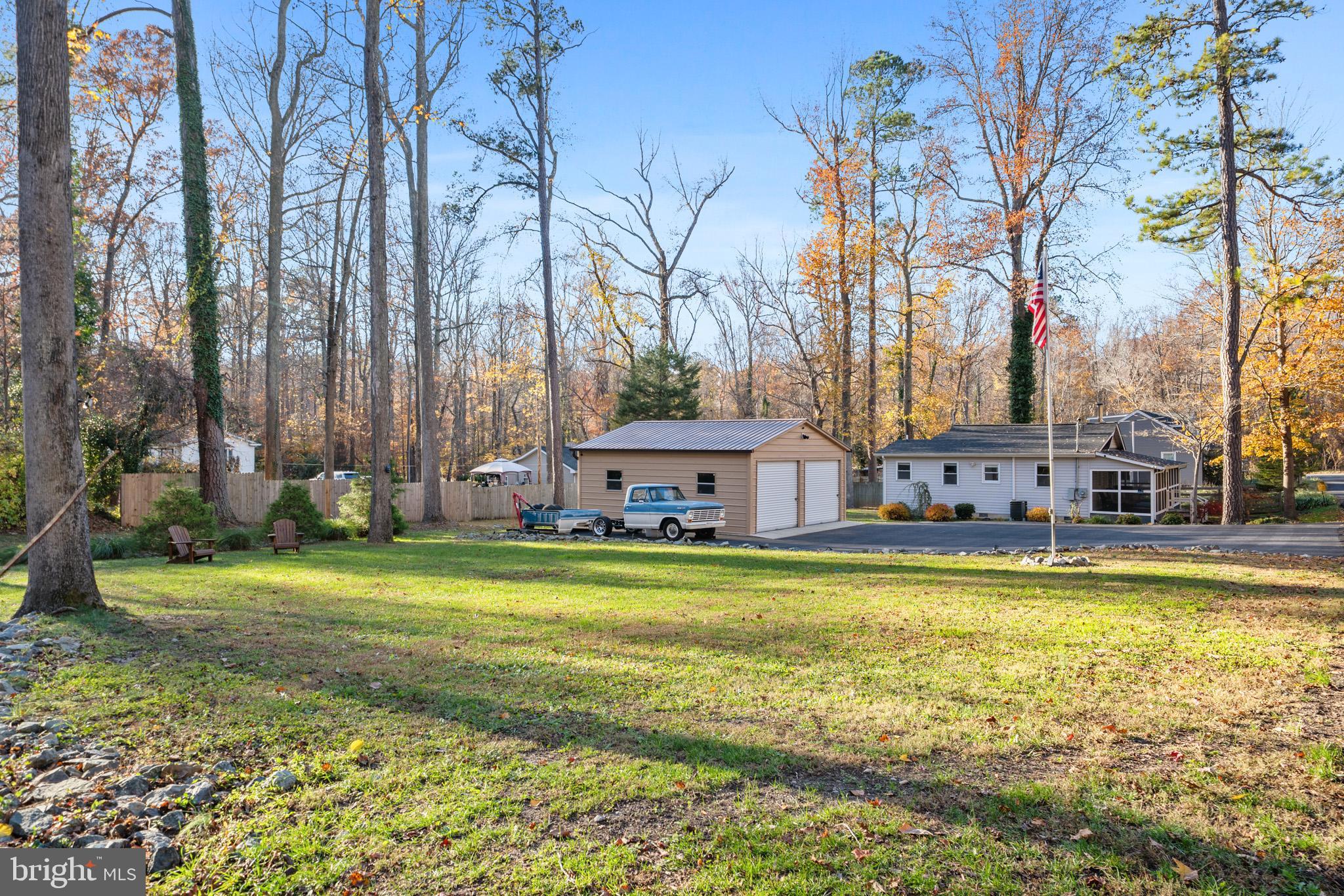 6015 Poplar Road St. Leonard, MD 20685 - Photo 1 of 35 a view of a large pool with lawn chairs under an umbrella