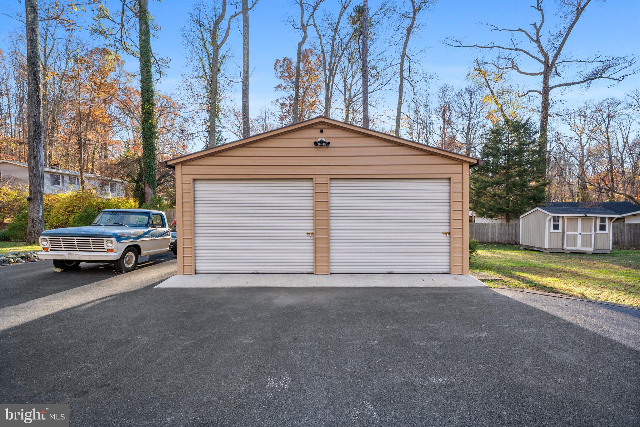 6015 Poplar Road St. Leonard, MD 20685 - Photo 3 of 35 a front view of a house with a yard and garage