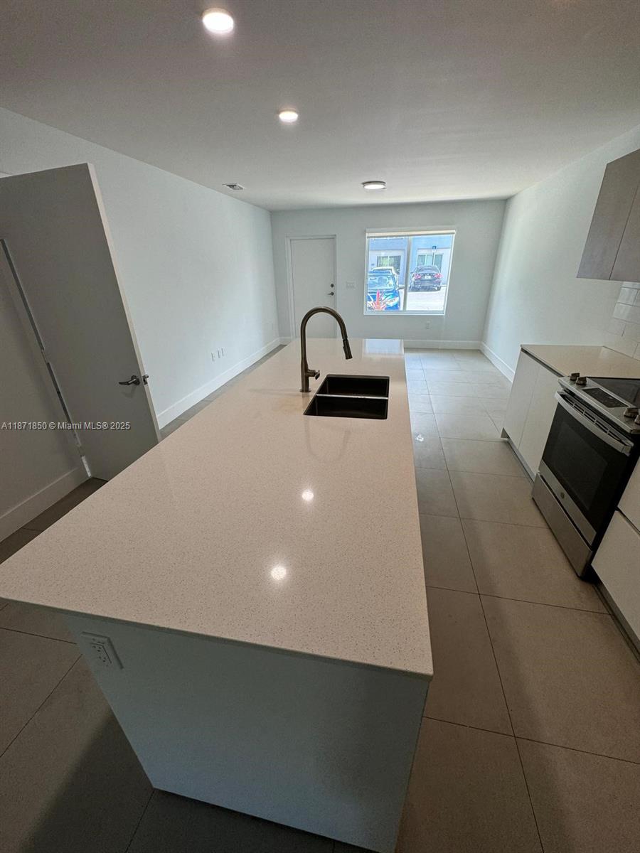 2555 Northeast 193rd Street, Unit 2106 Miami, FL 33180 - Photo 2 of 14 a kitchen with a sink and a stove top oven