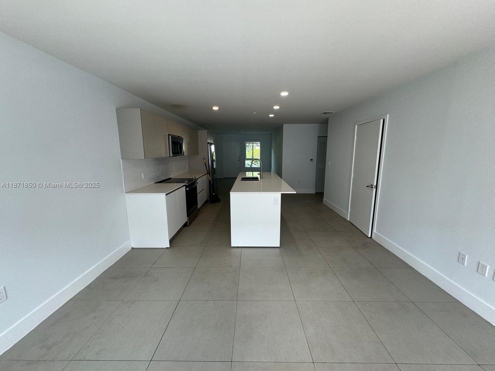 2555 Northeast 193rd Street, Unit 2106 Miami, FL 33180 - Photo 3 of 14 a kitchen with a refrigerator and a sink