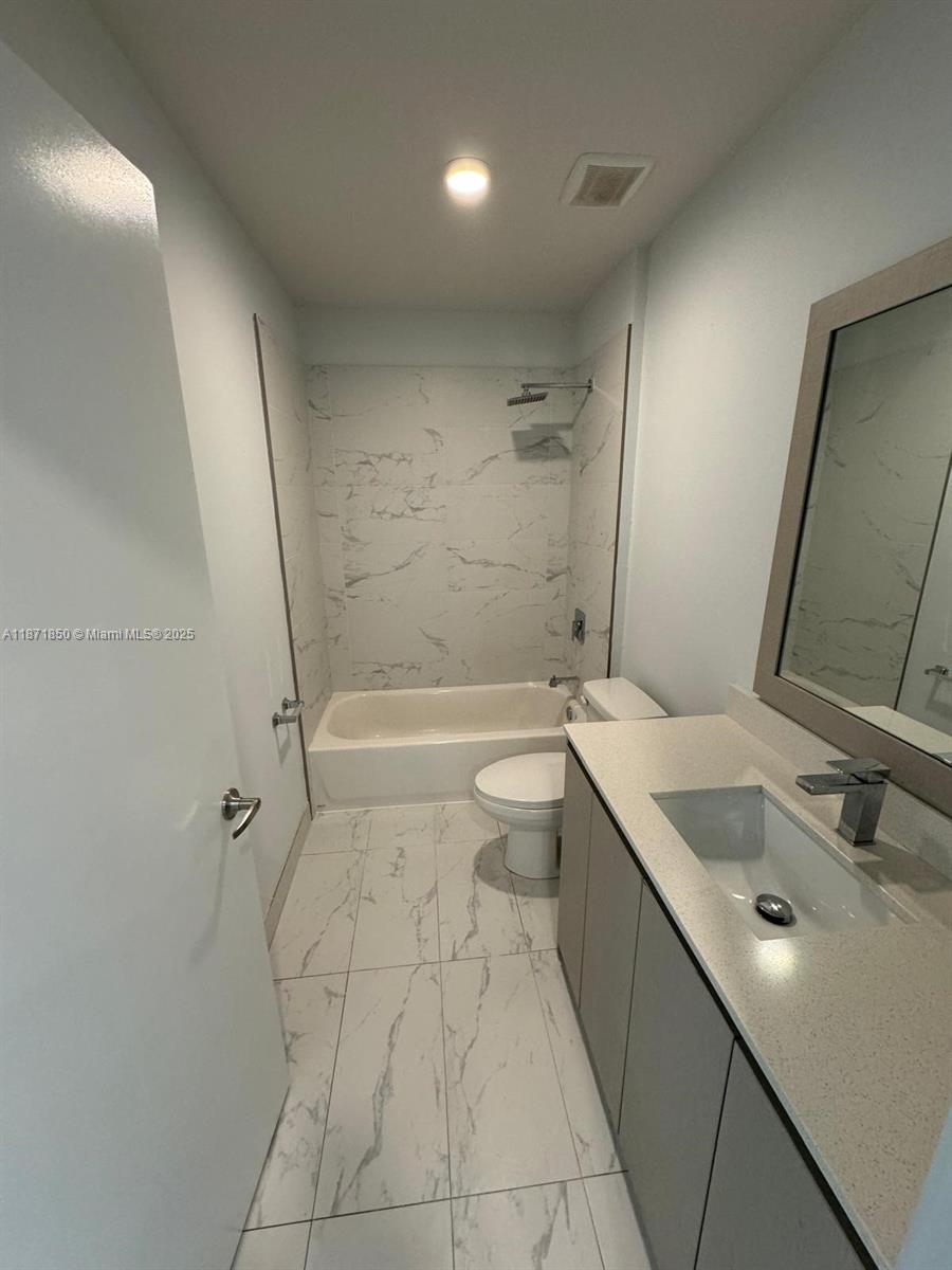 2555 Northeast 193rd Street, Unit 2106 Miami, FL 33180 - Photo 10 of 14 a bathroom with a sink a toilet and shower