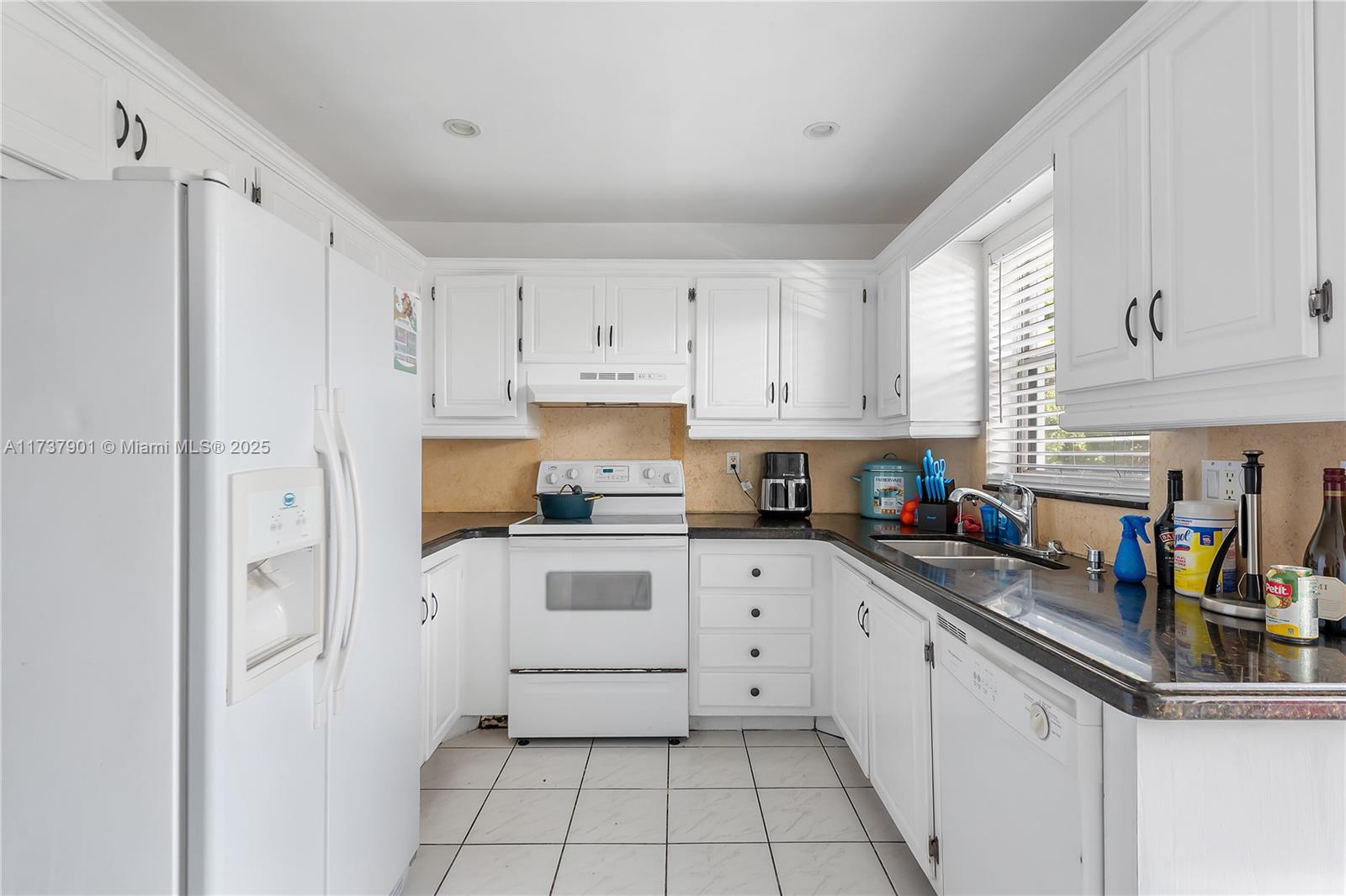 222 Southwest 1st Street, Unit H6 Pompano Beach, FL 33060 - Photo 5 of 15 a kitchen with white cabinets and white appliances