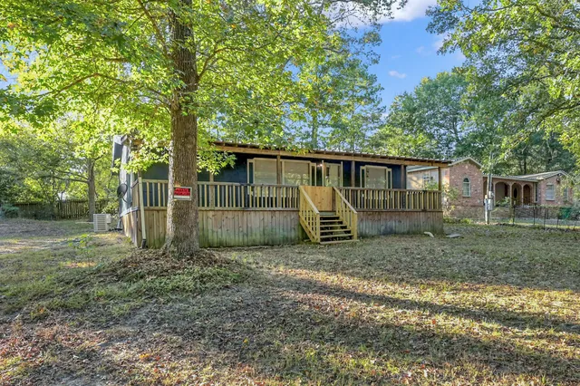 a view of a house with a yard and fence