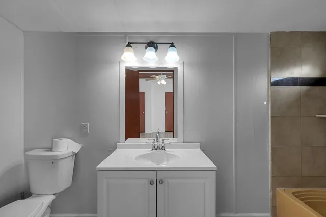 a bathroom with a toilet sink and mirror