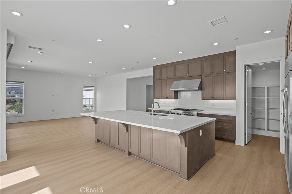 20638 Deer Grass Court Porter Ranch, CA 91326 - Photo 17 of 50 a large kitchen with stainless steel appliances a sink stove and cabinets