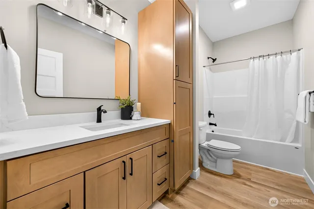 a bathroom with a double vanity sink toilet mirror and shower