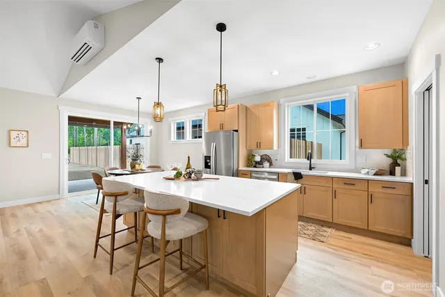 a view of a kitchen counter top space a sink a refrigerator and chairs
