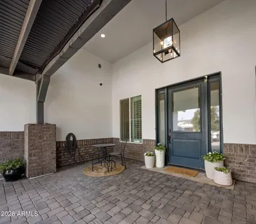 a view of a entryway door of the house with potted plants
