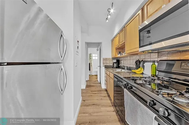 a kitchen with stainless steel appliances granite countertop a stove and a refrigerator