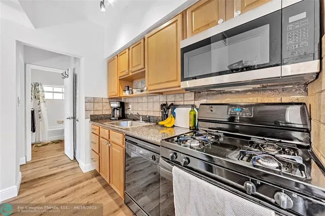 a kitchen with stainless steel appliances granite countertop a stove and a microwave
