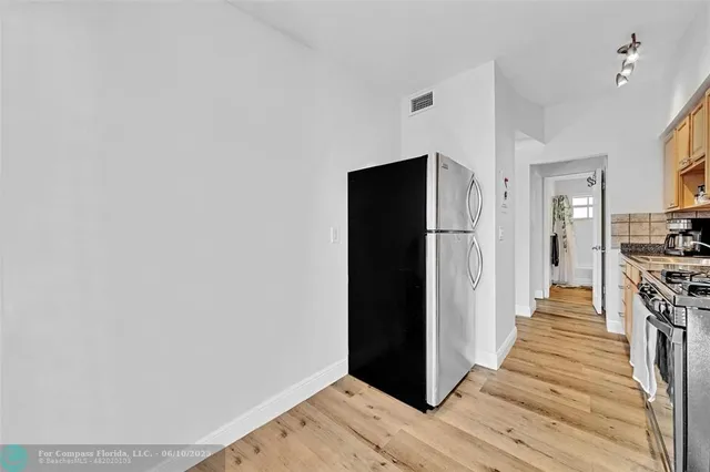 a view of a hallway with wooden floor and a living room