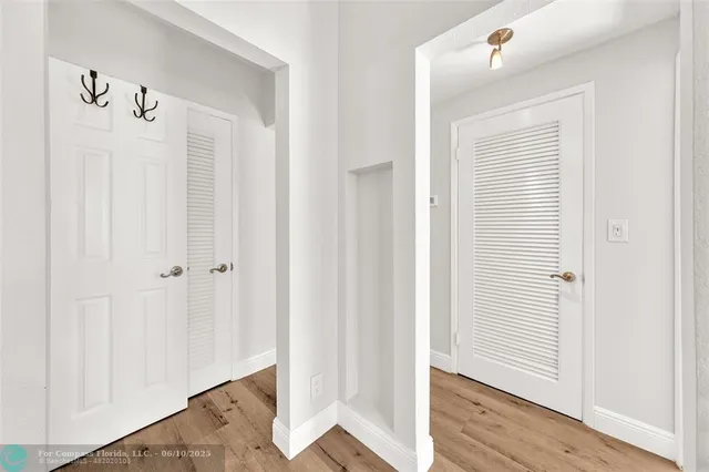 a view of a hallway with wooden floor and entryway