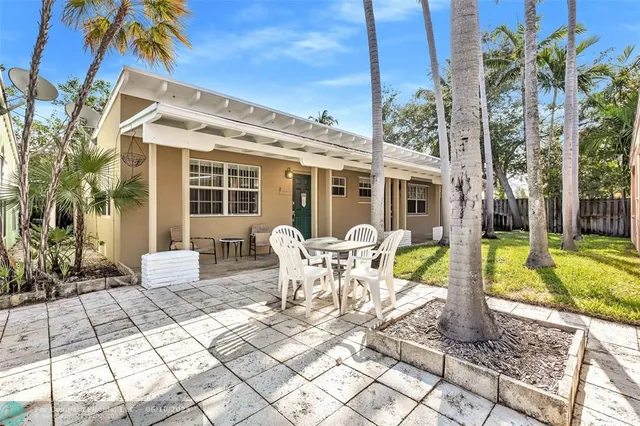 a view of a patio with table and chairs potted plants and palm tree