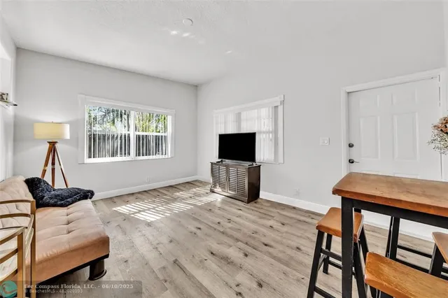 a living room with furniture a flat screen tv and a window