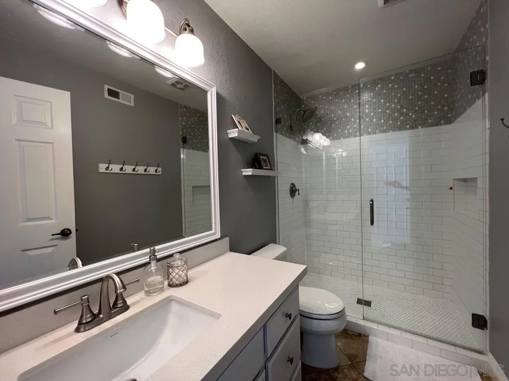 6805 Maple Leaf Drive Carlsbad, CA 92011 - Photo 11 of 22 a bathroom with a sink a toilet and shower