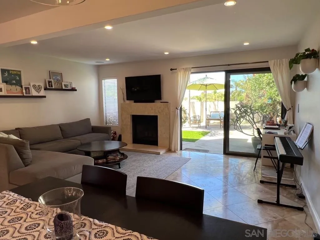 6805 Maple Leaf Drive Carlsbad, CA 92011 - Photo 4 of 22 a living room with furniture a flat screen tv and a fireplace
