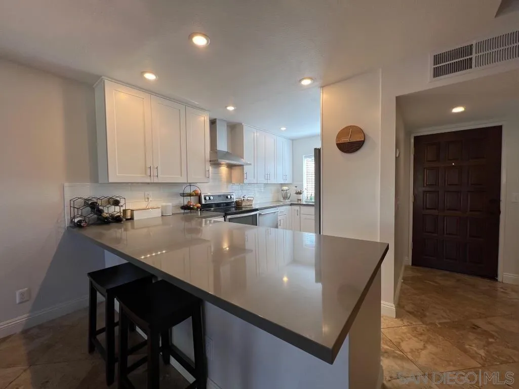 6805 Maple Leaf Drive Carlsbad, CA 92011 - Photo 6 of 22 a kitchen with kitchen island stainless steel appliances granite countertop a sink a stove and a refrigerator