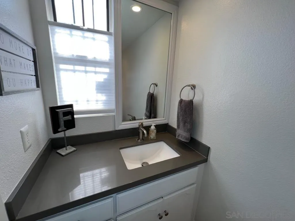 6805 Maple Leaf Drive Carlsbad, CA 92011 - Photo 9 of 22 a bathroom with a sink and a mirror