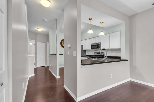 a kitchen with stainless steel appliances granite countertop a sink and a granite counter tops with wooden floors