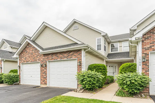 a view of house with a big yard and large trees