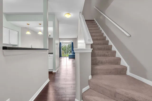 a kitchen with kitchen island a sink stainless steel appliances and white cabinets