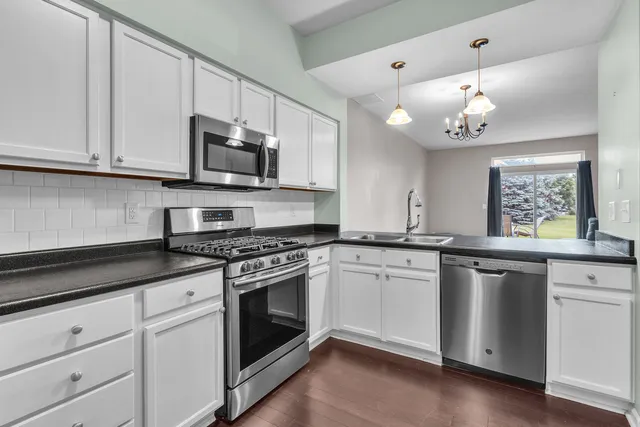 a kitchen with a sink cabinets and wooden floor