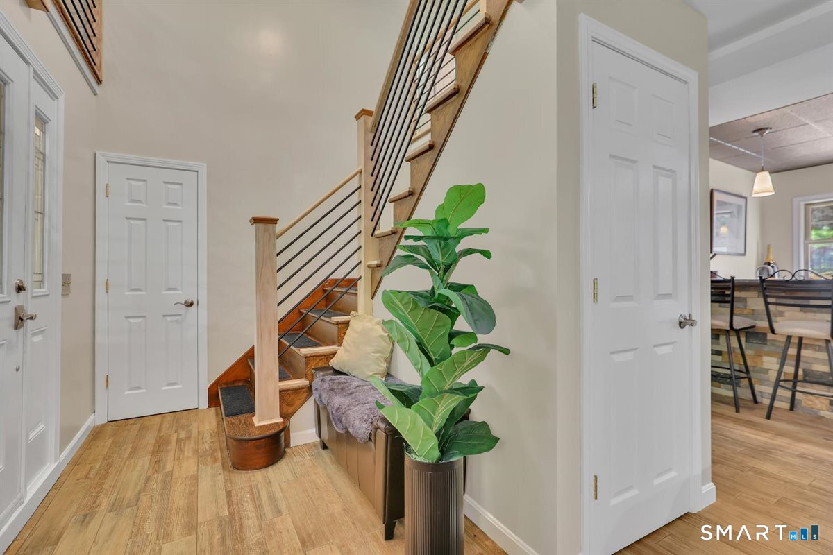 122 Ridgeview Circle Guilford, CT 06437 - Photo 21 of 40 Main level front entryway features tiled flooring, leads to a family room (recreation area), wet bar, and access to the outdoor patio and pool area.