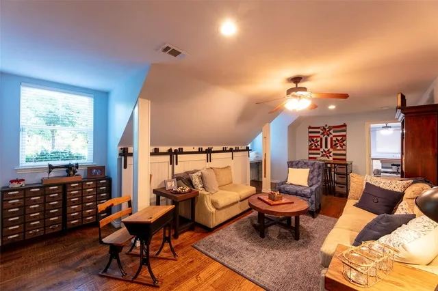 a room with furniture pool table wooden floor and windows
