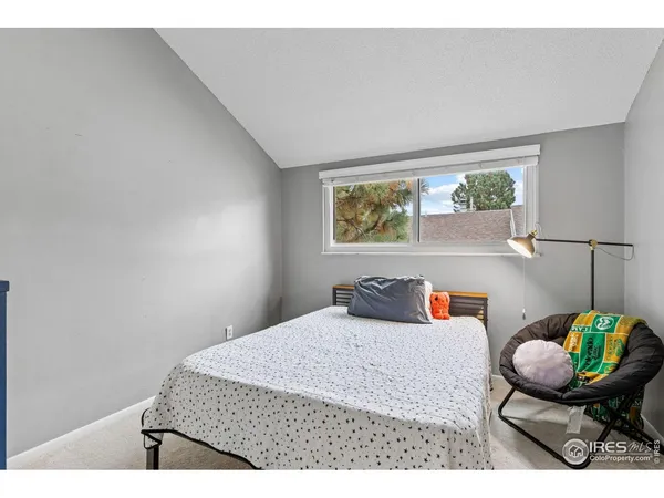 a bedroom with a bed and painting on the wall