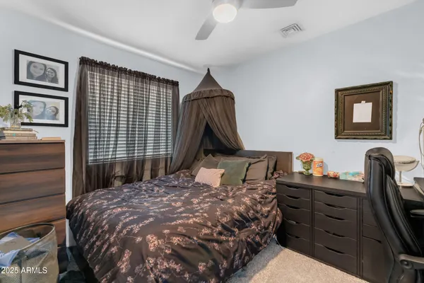 a bed sitting in a bedroom next to a cabinet