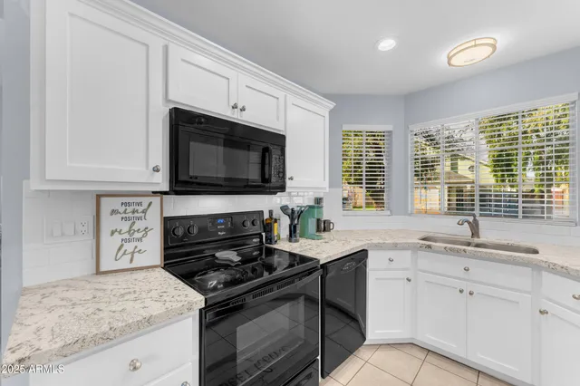 a kitchen with granite countertop a sink stove and microwave