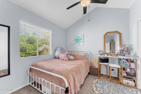 a bedroom with a bed a dresser and next to a window